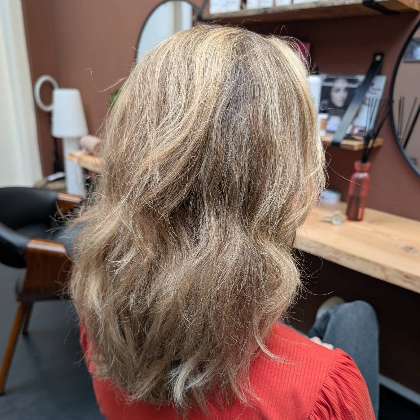Zachte blonde slagen, gekleurd en geföhnd in de salon