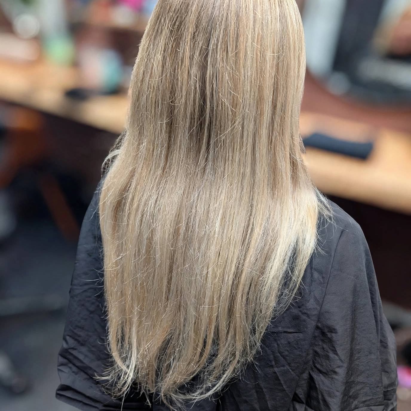 Lange blonde highlights, van achteren gezien in de salon
