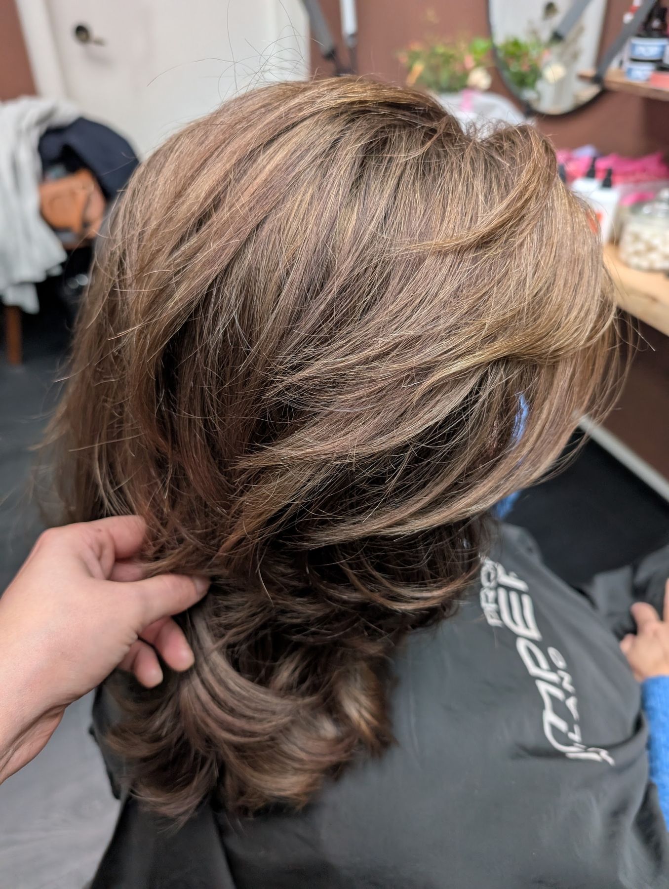 Geknipt in laagjes met zachte highlights, van achteren gezien in de salon